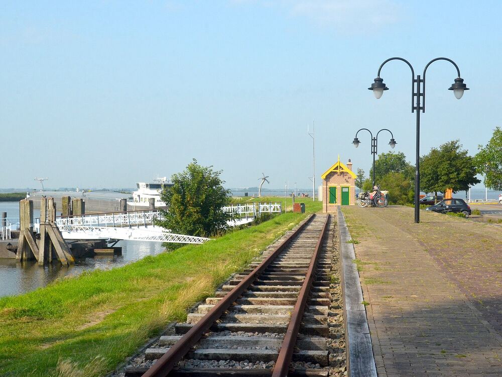 Oud tramspoor over de dijk bij Middelharnis Haven met lantaarnpalen en uitzicht over het water